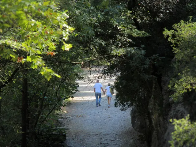 Couple marchant sur un chemin ombragé dans les Encanaux à Auriol, en pleine nature du massif de la Sainte-Baume.