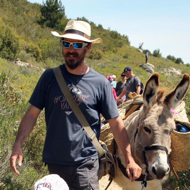 Balade d'un enfant et d'un adulte accompagné d'un âne sur un sentier dans un paysage naturel au Garlaban à Aubagne
