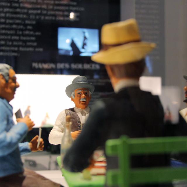 Santons représentant une scène provençale en discussion dans une exposition muséale au Petit Monde à Aubagne