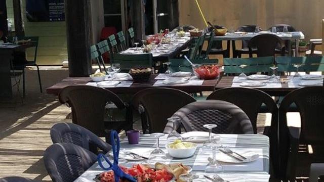 Tables dressées sous une pergola en bois pour un repas en plein air dans un environnement naturel à la buvette du domaine de font de mai à Aubagne