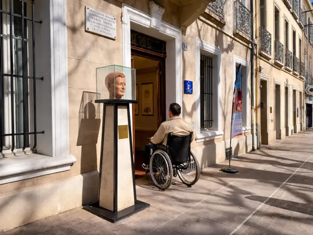 personne en fauteuil roulant entrant dans la maison natale de marcel pagnol